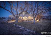 Charming home exterior with an arched porch, outdoor seating, and a beautifully landscaped yard at 1866 Park Lake Dr, Boulder, CO 80301