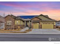 Beautiful single Gathering home showcasing stone accents, solar panels and a three car garage at 2292 Picadilly Cir, Longmont, CO 80503