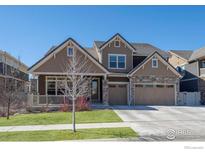 Charming two-story home features a three-car garage, stone accents, and a welcoming front porch at 386 Painted Horse Way, Erie, CO 80516