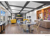 Elegant living room featuring a cozy fireplace, modern decor, and abundant natural light at 386 Painted Horse Way, Erie, CO 80516