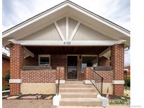 Charming red brick home featuring a covered front porch and traditional design at 4100 Eliot St, Denver, CO 80211