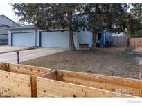 Charming home with a two-car garage and meticulous front yard landscaping, showcasing mature trees at 491 S Dover Ave, Lafayette, CO 80026