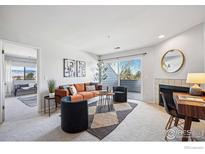 Bright living room with a fireplace, balcony, and comfortable seating arrangement at 4985 Twin Lakes Rd # 95, Boulder, CO 80301