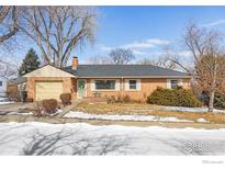 Charming brick home featuring an attached garage, well-kept lawn, mature trees, and classic design elements at 6 Sunset Cir, Longmont, CO 80501