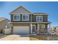 Charming two-story home featuring a covered porch, stone accents, and an attached two-car garage at 7231 Clarke Dr, Frederick, CO 80530