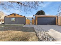 Charming home featuring a modern gray exterior, wood accents, and low-maintenance landscaping at 1200 Martin Rd, Longmont, CO 80504