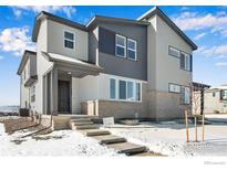 Charming two-story home featuring a covered porch entry and stylish gray and white siding details at 1525 E 3Rd Ave, Longmont, CO 80501