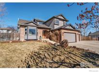 Charming two-story home featuring a brick facade, bay window and well-maintained lawn, perfect for curb appeal at 1826 Little Bear Ct, Longmont, CO 80504