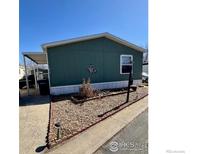 Charming green home with a covered carport and simple landscaping at 212 Skylark Cir, Lafayette, CO 80026