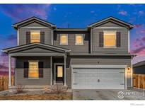 Charming two-story home featuring a gray exterior, covered front porch, and attached two-car garage at 2539 Alto St, Fort Lupton, CO 80621