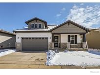 Charming two-story home featuring stone accents, a gray garage door, and a welcoming front porch at 2978 Newfound Lake Rd, Berthoud, CO 80513