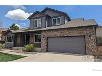 Two story home with blue siding, brick accents and a two car garage at 3232 Mariner Ln, Longmont, CO 80503