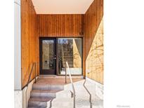 Inviting entrance to unit 101 with wood paneled walls, concrete steps and glass door and side window at 3233 Tejon St # 101, Denver, CO 80211