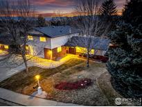 Beautiful two-story home featuring lovely landscaping and a warm, inviting exterior, set against a colorful sunset sky at 3549 Columbia Dr, Longmont, CO 80503