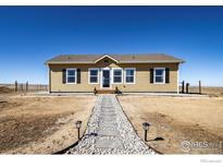 Charming tan home with black shutters, a stone walkway, and well-maintained landscaping at 47705 Private Road 19 Rd, Elizabeth, CO 80107