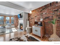 Inviting living room features a brick wall, fireplace, hardwood floors and plenty of natural light at 487 Pearl St, Boulder, CO 80302