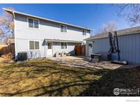 Spacious backyard featuring a patio with outdoor furniture and a well-maintained lawn at 937 Meeker St, Longmont, CO 80504