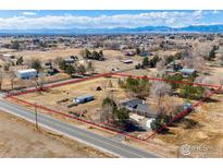 Expansive aerial view of a fenced property featuring a well-maintained home with mountain views in the distance at 15447 Huron St, Broomfield, CO 80023