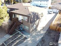 Brick two-story apartment building featuring a staircase to the main entrance and an asphalt shingle roof at 2241 Dexter Dr # 2, Longmont, CO 80501