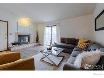Inviting living room with a decorative fireplace, ample seating, and a sliding door at 2800 Kalmia Ave # 320, Boulder, CO 80301