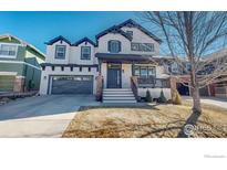 Charming two-story home with a covered front porch, gray garage door, and well-maintained landscaping at 3418 Fantasy Pl, Castle Rock, CO 80109