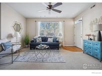 Bright living room featuring a large window, ceiling fan, comfortable seating, and stylish decor at 4501 Nelson Rd # 2303, Longmont, CO 80503