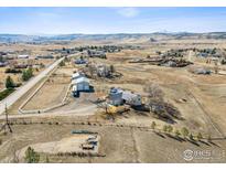 Expansive aerial view of a ranch-style home and acreage with mountain views at 4900 Beverly Dr, Berthoud, CO 80513