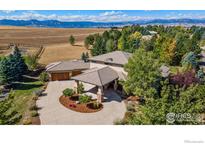 Stunning aerial view of a home with circular driveway and mountain views at 6425 Legend Ridge Trl, Niwot, CO 80503