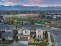 Beautiful two-story home featuring professional landscaping and a mountain backdrop view at 90 Moonrise Ct, Erie, CO 80516