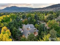 Stunning aerial view of the luxury home surrounded by lush greenery and mountains in the background at 1107 Juniper Ave, Boulder, CO 80304