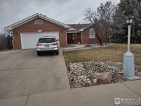 Charming single-story brick home featuring a two-car garage and well-maintained landscaping at 1191 Twin Peaks Cir, Longmont, CO 80503