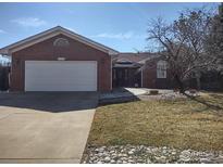 Charming brick home featuring a two-car garage and a well-maintained front yard at 1191 Twin Peaks Cir, Longmont, CO 80503