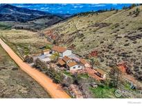 Stunning aerial view of a charming mountain home with sprawling grounds and scenic views at 16450 Dakota Ridge Rd, Longmont, CO 80503