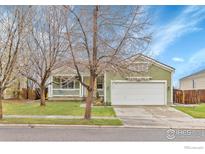 Charming single-story home featuring a two-car garage, well-maintained lawn, and welcoming front porch at 1665 Bain Dr, Erie, CO 80516