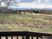 Scenic view from deck featuring open space, distant mountains, and neighborhood surroundings at 1665 Bain Dr, Erie, CO 80516