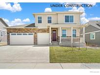 Charming two-story home with a brick-accented facade, covered porch, and well-manicured lawn at 1850 Sawtooth Mountain Dr, Berthoud, CO 80513