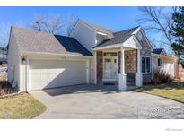 Charming home featuring a stone-accented entrance, attached garage and well-manicured lawn at 310 Diamond Cir, Louisville, CO 80027