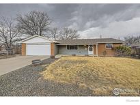 Charming single-story home with a well-maintained lawn and attached two-car garage at 313 Aspen Dr, Brighton, CO 80601