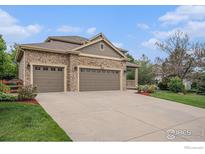 Inviting home featuring a stone facade, three-car garage, and a charming front porch at 4910 Crimson Star Dr, Broomfield, CO 80023