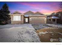 Charming ranch-style home boasting a two-car garage and a well-maintained lawn dusted with snow at 5870 Scenic Ave, Firestone, CO 80504