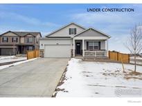 Charming two-story home featuring a welcoming front porch and attached two-car garage at 6501 14Th St, Frederick, CO 80530