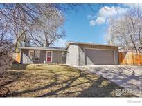 Charming single-story home featuring a two-car garage, well-maintained lawn, and inviting curb appeal at 7711 Nikau Dr, Niwot, CO 80503