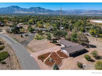 Expansive aerial view of a ranch home with beautiful landscaping and mountain views at 1147 Crestmoor Dr, Boulder, CO 80303