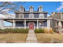 Charming two-story home with a covered front porch and meticulously landscaped yard, perfect for curb appeal at 1403 Armstrong Dr, Longmont, CO 80504