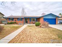 Charming brick home featuring a blue-trimmed exterior and well-maintained front yard, creating a welcoming curb appeal at 19 University Cir, Longmont, CO 80503