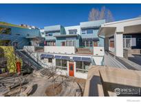 Modern townhome complex featuring solar panels, decks, and colorful facades with blue skies above at 2018 Ionosphere St # 6, Longmont, CO 80504