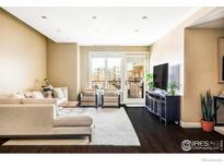 Bright living room featuring a comfortable sectional sofa and balcony access for indoor-outdoor living at 3301 Arapahoe Ave # 204, Boulder, CO 80303