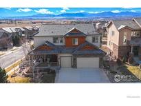 Beautiful two-story home with a stone-accented facade and a well-maintained front yard with mountain views at 15955 Humboldt Peak Dr, Broomfield, CO 80023