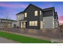 Charming modern two-story home with gray and white siding, a well-kept lawn and gravel landscaping at 1784 Glacier Ave, Berthoud, CO 80513