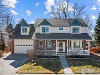 Charming two-story home with a brick and siding facade, a well-manicured lawn, and a welcoming front porch at 2111 Pintail Dr, Longmont, CO 80504